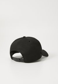 Fekete sapka ívelt csúccsal, szövetből készült. Állítható snapback záródással, szellőző lyukakkal és sima textúrával rendelkezik.