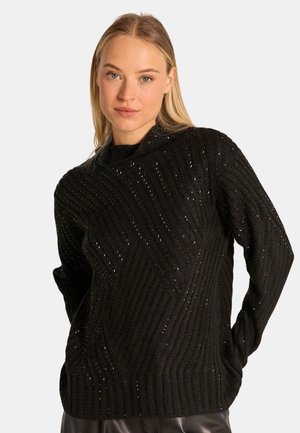 Suéter de punto negro con un cuello alto, textura de canalé y un patrón diagonal con sutiles acentos de brillo.