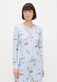 Svijetloplava dugoslijepa kardigan s dugim rukavima i gumbima, izrađen od meke tkanine, s maštovitim uzorkom pekarskih proizvoda i cvjetnih aranžmana.