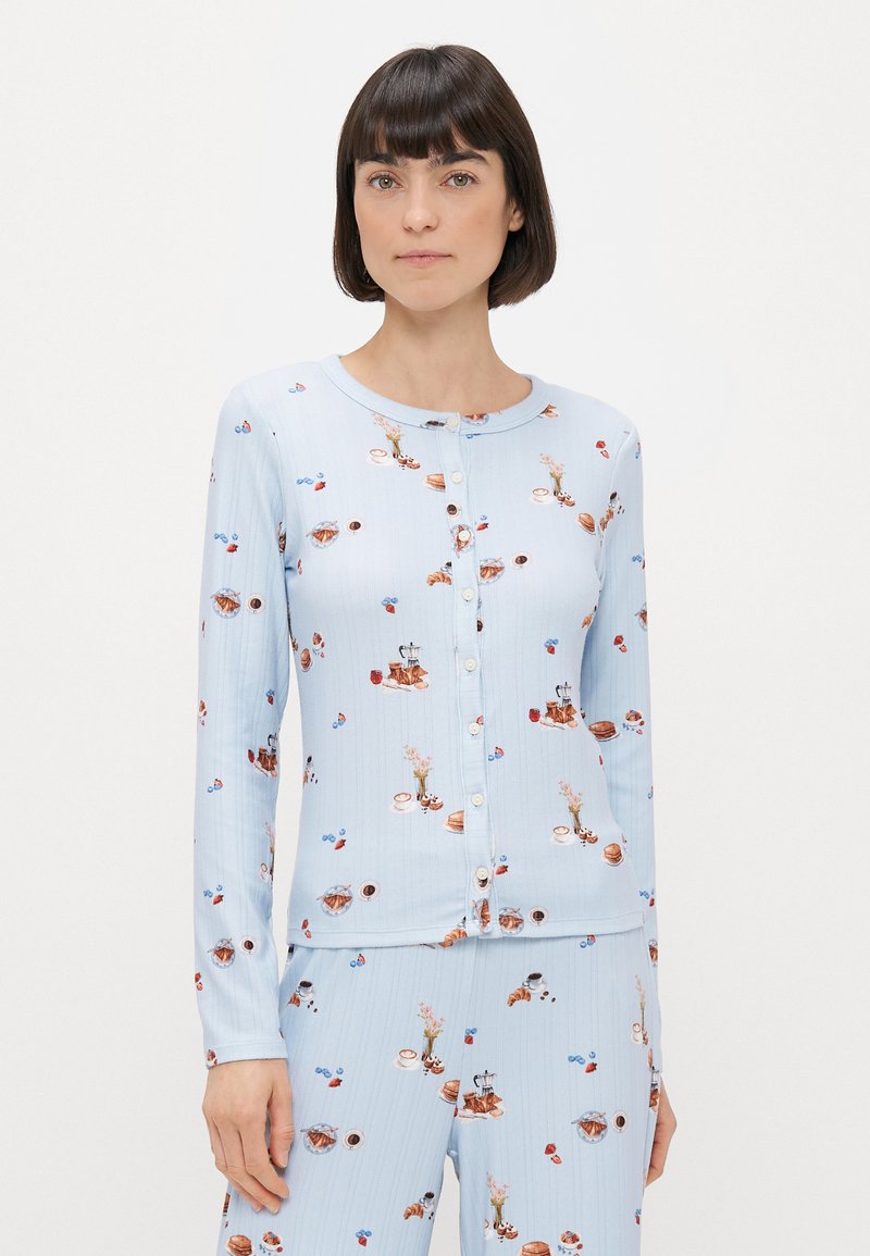 Svijetloplava dugoslijepa kardigan s dugim rukavima i gumbima, izrađen od meke tkanine, s maštovitim uzorkom pekarskih proizvoda i cvjetnih aranžmana.