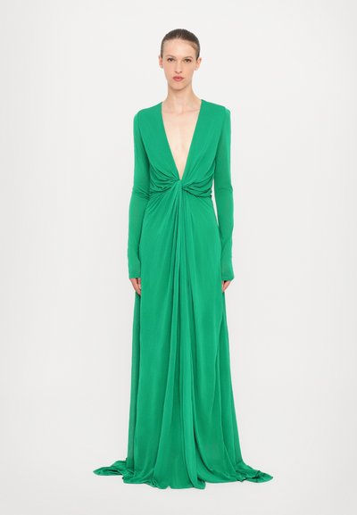 Robe verte à manches longues et décolleté en V profond, fabriquée en tissu fluide, avec un nœud torsadé à la taille et une silhouette longueur de sol.