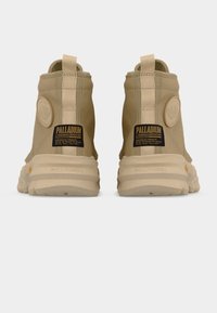 Μπεζ ψηλά sneakers με επάνω μέρος από υφασμάτινο καμβά με υφή, επενδεδυμένο κολάρο και καουτσούκ σόλα. Διαθέτουν εμπορικά σήματα στο πίσω μέρος και θηλιά έλξης.