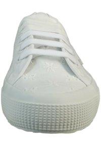 Sneaker bianco con tomaia in tessuto testo caratterizzata da motivi floreali, lacci bianchi piatti e suola in gomma testurizzata.