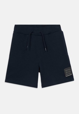 Marineblaue Kindershorts mit elastischem Bund und Kordelzug, mit einem "COOL COOL COOL" Aufnäher am unteren linken Bein.