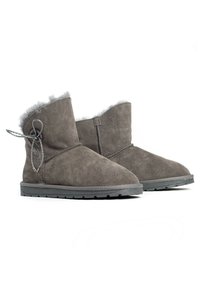 Botas de tobillo de ante gris con suave forro de piel gris, forma curvada y detalle de encaje decorativo en el costado, con suela plana de goma.
