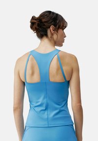 Blauwe sporttanktop met een soepele textuur, met een racermaken ontwerp en uitsparingen op de schouders.