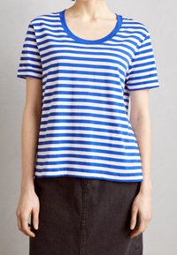 Camiseta de rayas azul y blanca con escote amplio y mangas cortas, confeccionada en una suave mezcla de algodón. Diseño de corte recto.