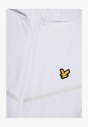 Giacca bianca con cerniera frontale, striscia riflettente orizzontale e piccolo logo di un uccellino giallo sul petto.