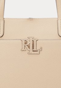 Bežna torba od teksturirane kože s istaknutim urezanim logom "RL" u svjetlijoj nijansi, uz kontrastnu šav.