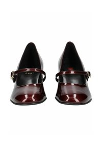 Scarpe Mary Jane in pelle verniciata borgogna con punta a forma di freccia, cinturino alla caviglia e una leggera lucentezza. Suola in gomma nera, design minimalista.
