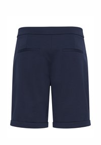 Shorts bleu marine sur mesure avec revers aux ourlets et deux poches passepoilées à l'arrière, conçus pour un look soigné et formel.
