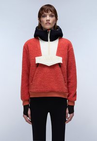 Rød fleece pullover med høj krave, kontrasterende cremefarvet frontpanel. Accenteret med et hvidt logo patch og sorte ærmer, med en afslappet pasform.