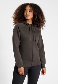 Mörkgrå zip-up hoodie i mjukt tyg, med huva, långa ärmar och snörningsdetaljer. Ribbstickade mudd och fåll.