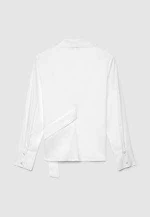 White long-sleeve shirt with a classic collar. Features a unique back design with a side tie. Smooth, woven fabric and buttoned cuffs.
