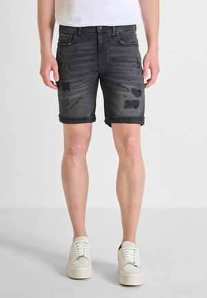 Donkergrijze denim shorts met verwerkte accenten en opgerolde zomen, voorzien van vijf zakken en een knoopsluiting aan de voorkant.