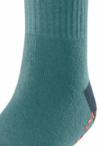 Morski zielony skarpet z żebrowaną fakturą i granatowym akcentem na pięcie, z jasnopomarańczowym logo po boku. Skarpet skoncentrowany na komforcie i dopasowaniu.