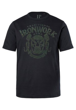 T-shirt nero a maniche corte in cotone, con una grafica di teschio verde e strumenti incrociati, accompagnata dal testo "Traditional Ironwork Comp."