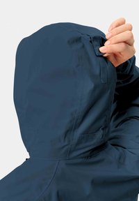 Giacca impermeabile blu navy con cappuccio. Caratteristiche: maniche regolabili e una texture liscia. Include cuciture sottili e un design elegante.