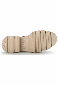 Suela de zapato de goma beige con profundas ranuras y estrías para tracción. Marca prominente grabada en la superficie. Forma plana y ancha.