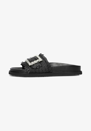 Sandale mule tissée noire avec semelle plate et grande boucle carrée en strass sur la bride.