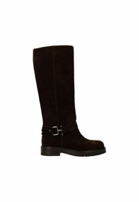 Bottes hautes en suède marron avec une semelle plate, comportant deux sangles horizontales et un accent de boucle en argent au niveau de la cheville.