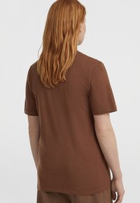 Bruine t-shirt met korte mouwen, gemaakt van zachte stof, met een ontspannen pasvorm en een ronde halslijn en een subtiele textuur. Achteraanzicht weergegeven.
