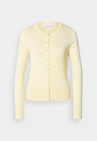 Cardigan jaune en maille douce, avec un col rond, des manches longues et une fermeture à boutons sur le devant. Poignets et ourlet côtelés.