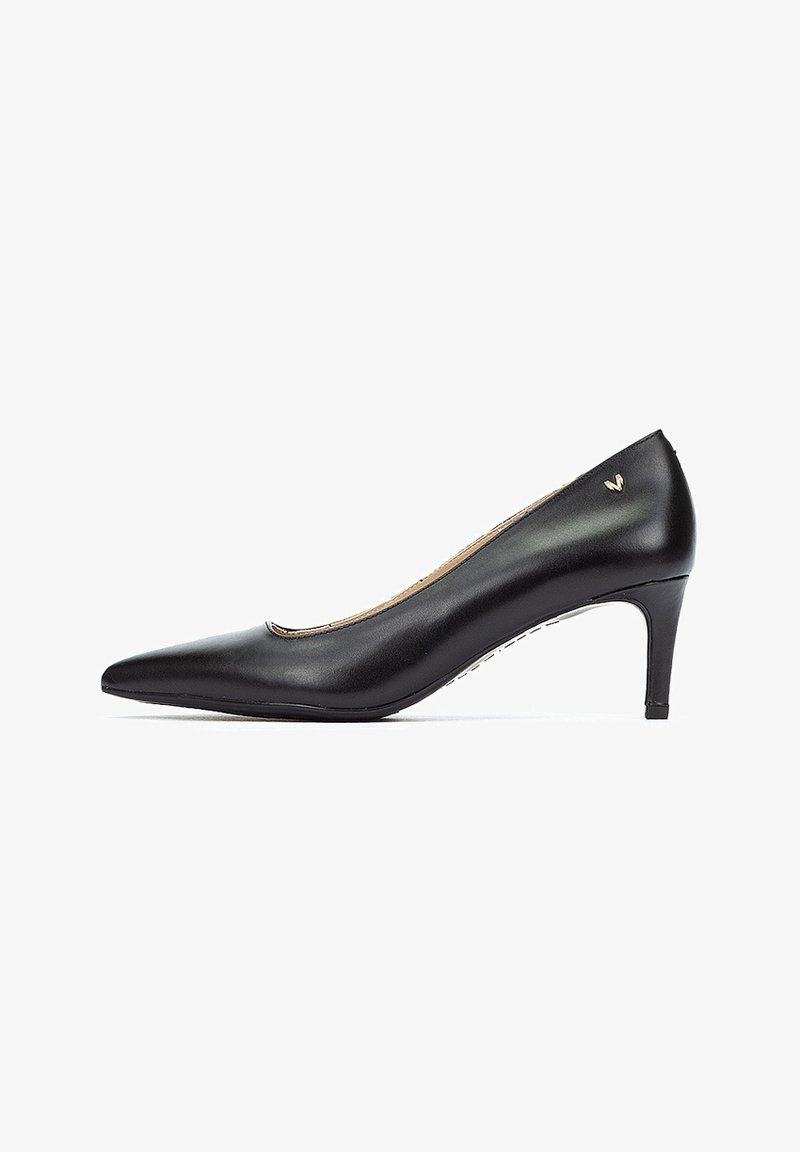 Zapato de tacón negro de piel con punta afilada y tacón delgado, que cuenta con un sutil acento de logotipo dorado, textura suave y un diseño elegante.