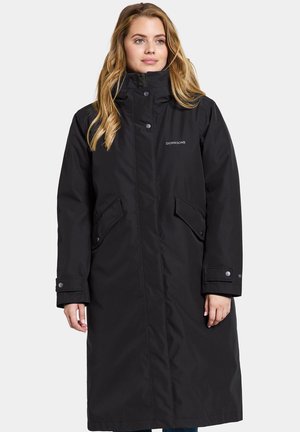 Black long parka with a high collar, zip closure, and snap buttons. Features two front pockets and a logo on the chest. Waterproof material.