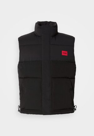Black puffer vest with high collar, featuring a red rectangular logo, two front pockets, and drawstrings at the hem for adjustable fit.