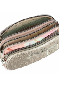 Neceser de maquillaje multifuncional en plata metálica, con cierres de cremallera, cuero texturizado y forros interiores coloridos y estampados.