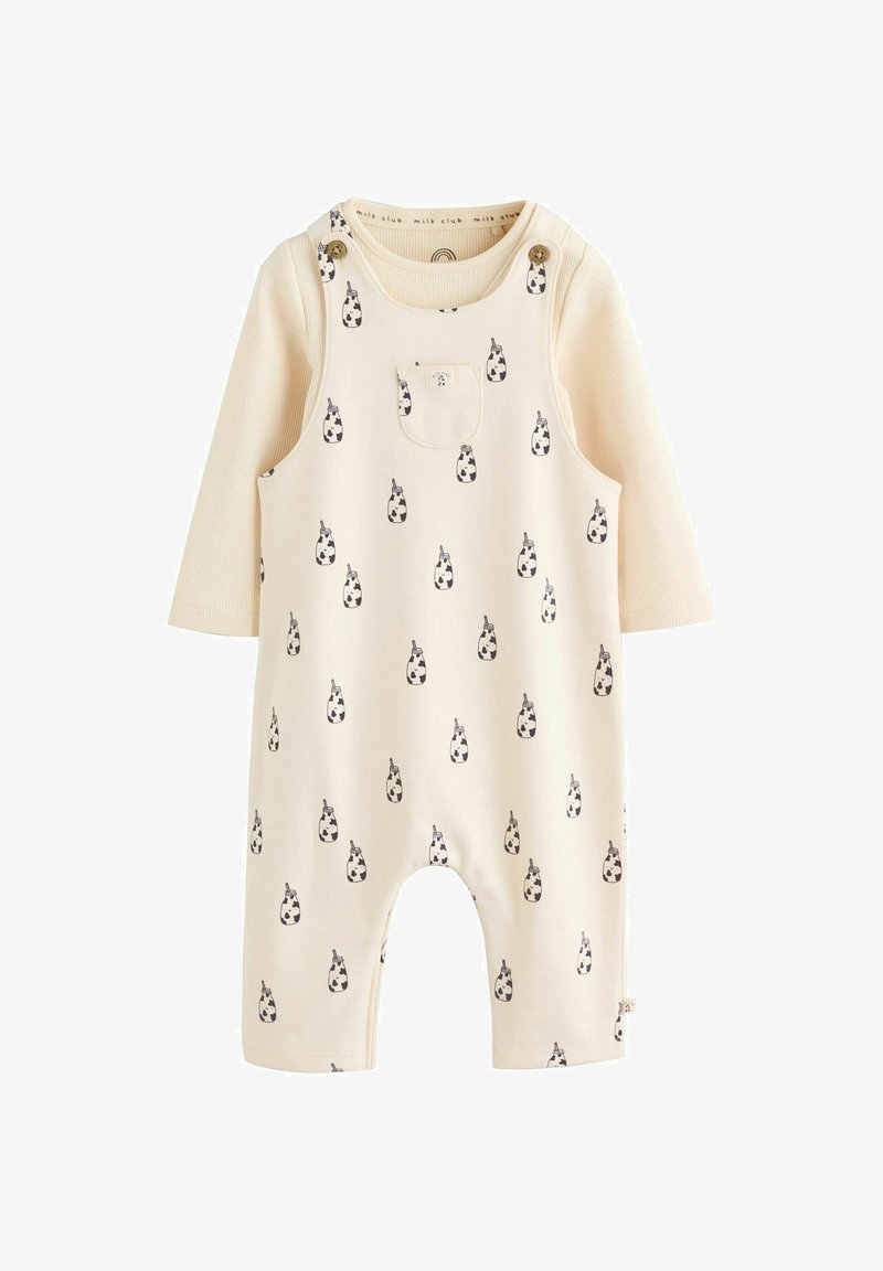 Grenouillère pour bébé couleur crème à manches longues avec de petits motifs de biberons noir et blanc, dotée de bretelles à boutons et d'une poche avant.