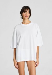 Witte oversized t-shirt gemaakt van katoen. Kenmerkt zich door een ronde hals en korte mouwen, met een soepele textuur en eenvoudig ontwerp.