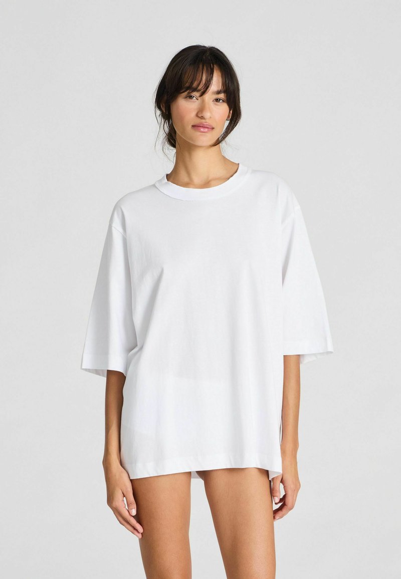 Witte oversized t-shirt gemaakt van katoen. Kenmerkt zich door een ronde hals en korte mouwen, met een soepele textuur en eenvoudig ontwerp.