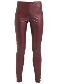 Bordowe legginsy z ekoskóry o błyszczącym wykończeniu, charakteryzujące się dopasowanym krojem oraz brakiem widocznych elementów metalowych czy wzorów.