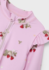 Rosa one-piece plagg med dragkedja, prydd med jordgubbs- och blommönster. Har volangdetaljer på axlarna och ett stretchigt material.