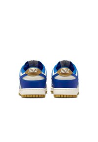 Nike sneakers featuring a blue leather upper, white accents, gum rubber sole, and a beige heel tab with logo. Rounded design with padded collar.