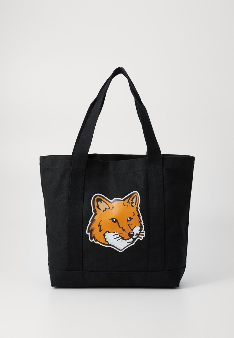 Sac en toile noir avec un motif de tête de renard orange sur le devant, doté de poignées noires robustes et d'une forme structurée.