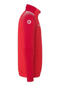 Red athletic jacket with a high collar, textured shoulder design, and zippered side pockets. Features logo on the sleeve and smooth fabric.