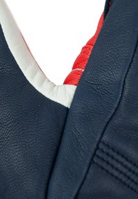 Blått lädermaterial med vita och röda accenter. Designen har en strukturerad yta som visar upp sömmar och rundade kanter.