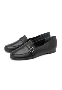 Črne usnjene loafer čevlje s stranskim sponko, nizkimi petami in elegantno, gladko površino, prikazani na beli ozadju.
