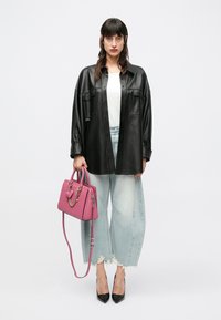 Μαύρο δερμάτινο υπερμεγέθες πουκάμισο, λευκό τοπ, ανοιχτό μπλε τζιν παντελόνι φαρδιάς γραμμής με ξέφτια στο τελείωμα, ροζ τσάντα με διακοσμητικό καρδιά, μαύρες μυτερές γόβες.