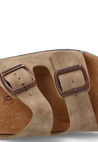 Sandal de ante beige con dos hebillas metálicas ajustables marrones, plantilla contorneada y logo "VERA PELLE" en relieve en la plantilla.