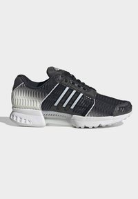 Czarny i szary sportowy but z białą podeszwą, cholewką z siateczki, sznurowanym zapięciem oraz trzema odblaskowymi paskami po boku.