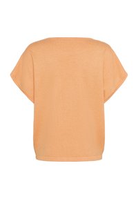 Maglietta a maniche corte, dalla vestibilità ampia, realizzata in morbido tessuto color pesco, con scollatura rotonda e orlo leggermente curvato.
