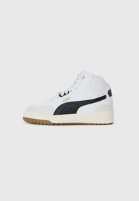 Hvit mid-top sneakers med svart Puma-stripe, beige tåhette, gummisåle og hvite snøring mot en enkel grå bakgrunn.