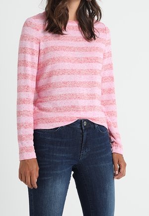 Maglione a righe rosa e bianche realizzato in morbido tessuto a maglia, caratterizzato da un collo rotondo e maniche lunghe, abbinato a jeans blu scuro.