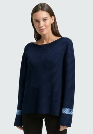 Pull en tricot bleu marine avec un motif texturé, encolure large et manches longues avec des poignets à motif bleu clair.