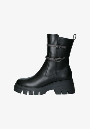 Stivale alla caviglia in pelle nera con due cinturini decorativi, zeppa chunky e fascia rinforzata sul tallone. Texture liscia e design elegante.
