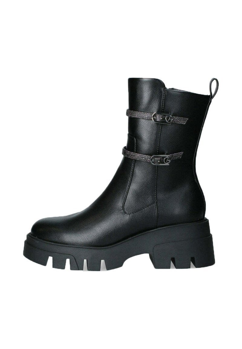 Stivale alla caviglia in pelle nera con due cinturini decorativi, zeppa chunky e fascia rinforzata sul tallone. Texture liscia e design elegante.